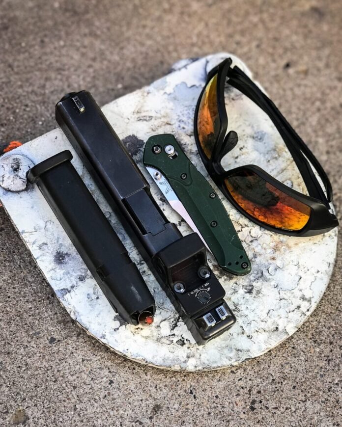 Photo by STNGR LLC black framed sunglasses on gray and white marble table