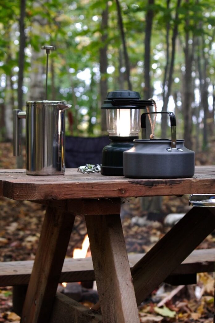 Photo by Danielle-Claude Bélanger a picnic table with a coffee pot and a kettle on it