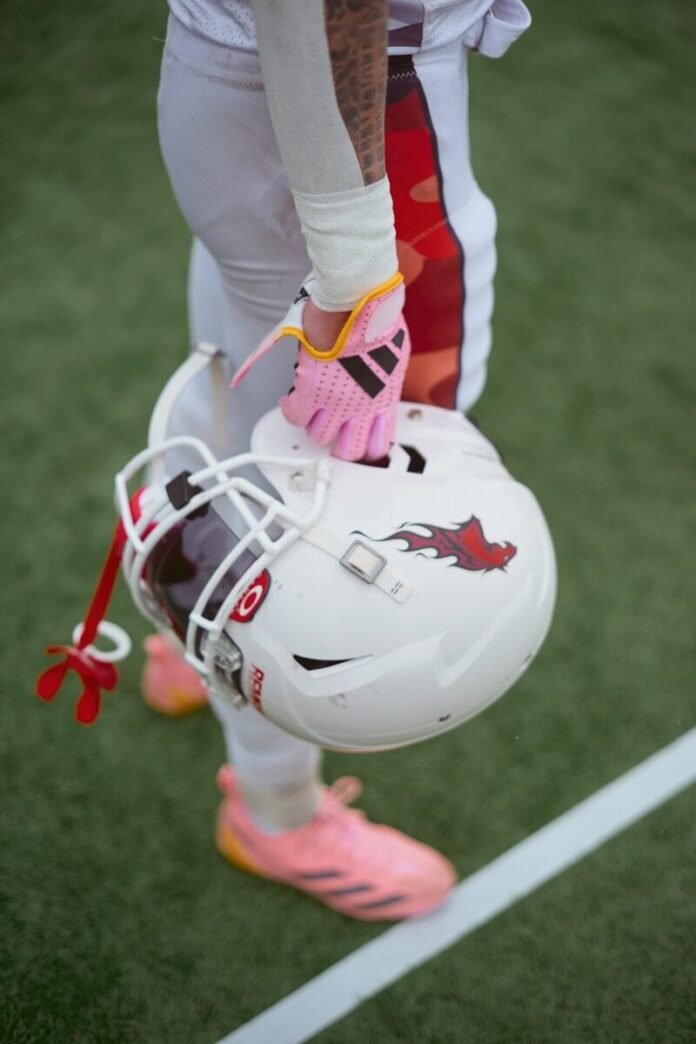 Photo by Preillumination SeTh Football player holding a helmet on a field
