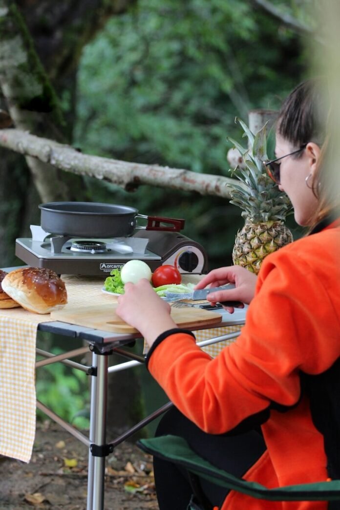 Photo by Kampbros a woman sitting at a table with a plate of food