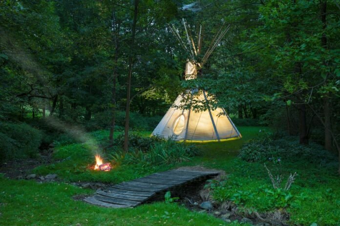 Photo by Randy Fath white tent in forest during night time